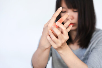 Woman has pain in her knuckles or hand from heavy use on white background.