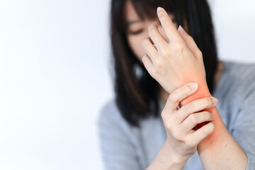 Woman has wrist pain or arm pain from heavy use on white background.
