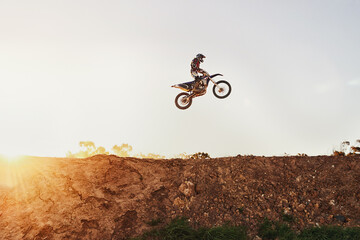 Person, jump and motorcyclist in the air on mockup with sunset for trick, stunt or ramp on outdoor...