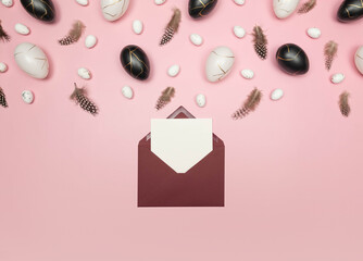 Top view of easter eggs, feathers, red envelope and white card on pink background. Creative easter composition, spring, flat lay, copy space.