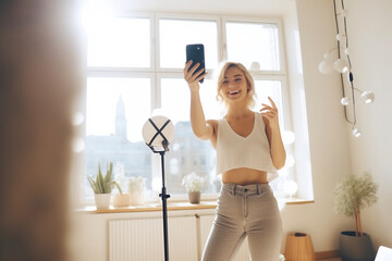 Fototapeta na wymiar Joyful Young Woman Creating Content with Smartphone on Tripod. Social Media and Lifestyle Influencer