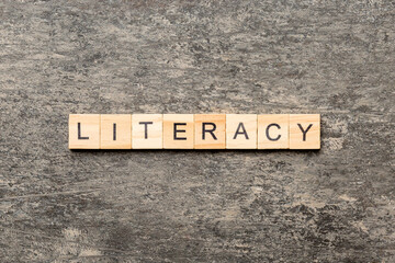 LITERACY word written on wood block. LITERACY text on cement table for your desing, concept