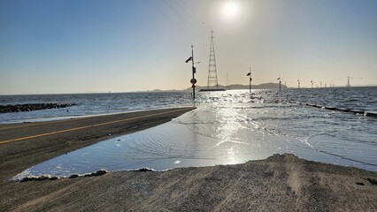 the view of the road submerged in the sea at high tide
