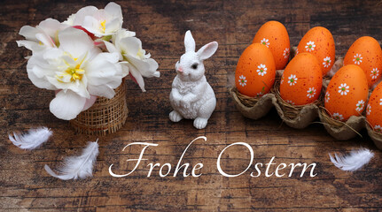 Grußkarte Frohe Ostern: Osterhase, Blumen und Ostereier auf rustikalem Holz dekoriert mit der...
