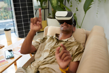 Smiling man in virtual reality headset watching video on installing solar system