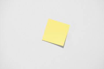 Yellow sticky note on white wall