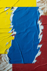 Peeled blue, yellow and red paper poster texture background