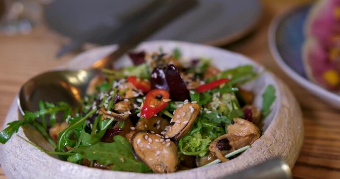 Fresh salad from seafood: octopus, cuttlefish, shrimp. Sea salad on white dish rotating.