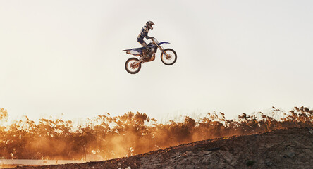 Person, jump and professional motorcyclist on mockup in the air for trick, stunt or ramp on outdoor...