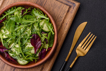 Delicious fresh salad with arugula, spinach, cucumber and cherry tomatoes in a ceramic plate