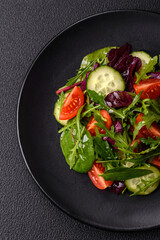 Delicious fresh salad with arugula, spinach, cucumber and cherry tomatoes in a ceramic plate