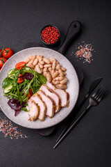 Delicious dietary salad with arugula, cucumber and cherry tomatoes and chicken breast slices