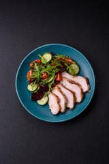 Delicious dietary salad with arugula, cucumber and cherry tomatoes and chicken breast slices