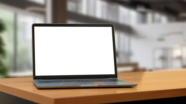 Laptop computer on desk at office or co-working space, Laptop with white blank on screen and blurred background , working space concept.