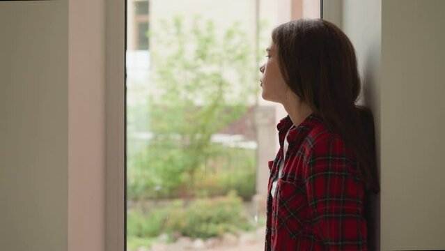 Pensive woman stands alone in corridor. Thoughtful lady suffers from parents refusing to accept homosexuality at home. Mental health disorders impact