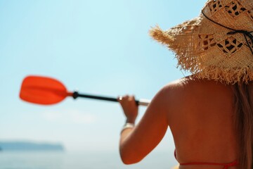 Woman in kayak back view. Happy woman with long hair in a swimsuit and hat floating in kayak on the sea. Summer holiday vacation. Summer holidays vacation at sea.