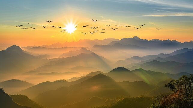 A serene sunrise illuminates a layered mountain landscape with a flock of birds flying across the golden sky.