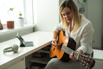 Home Guitar Playing Lesson Girl Hold Instrument. Beautiful Woman at Musical Training. Blonde with...