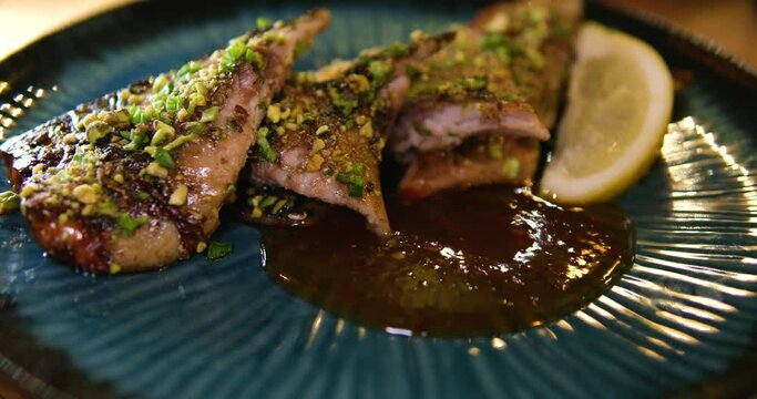 Chef Cooked Mackerel Fish On BBQ. Frying Fish Dishes Scomber On Home Kitchen. Healthy Food No Fat. on a blue plate pieces of fried mackerel with sweet and sour sauce and lemon, delicious food serving