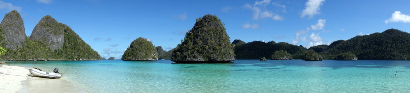 Panorama of rock islands of Wayag Indonesia Raja Ampat with Dinghi on the beach
