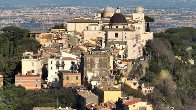 Aerial view of the Papal Palace of Castel Gandolfo. The Apostolic Palace is a complex of buildings served for centuries as a summer residence for the Pope. In background the city of Rome, Italy. 