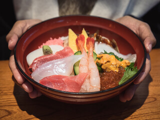 Big set of mix sashimi - fresh fish on top of rice bowl in Japanese restaurant
