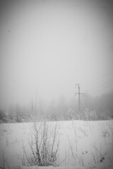 winter landscape, snow-covered field and high-voltage lines