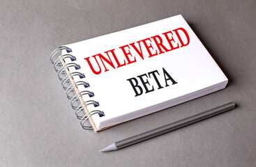UNLEVERED BETA word on notebook on grey background