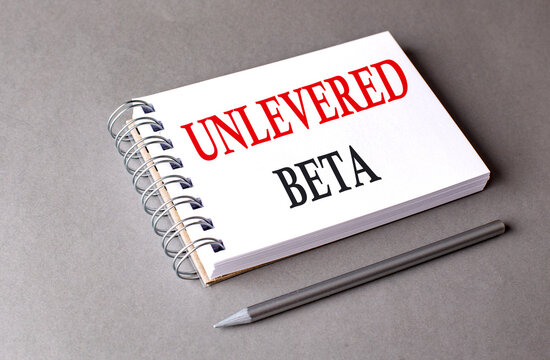 UNLEVERED BETA word on notebook on grey background