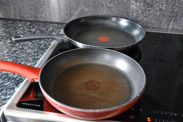 Teflon pans on the induction hob in the kitchen