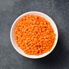 Close-up of lentils in a ceramic bowl. On a dark concrete background.