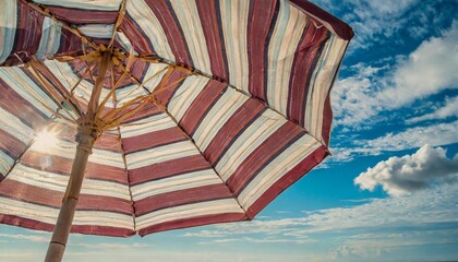 striped beach umbrella over blue sky