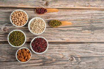 Mung beans, Red kidney beans, Chickpeas source and peeled barley in white cup on spoon wooden on wood background