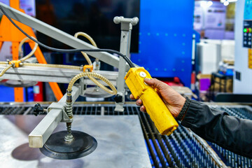 A worker is pressing a steel plan control button to enter the steel cutting process in the...