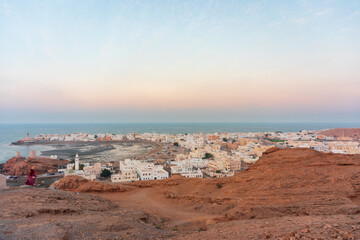 West part of Sur town with Al-Ayjah Castle, mosque in golden hour, Oman.