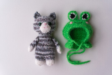 Knitted toy cat with a toad cap on a white background - 743656874