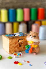 Knitted hamster toy with yarn and knitting accessories
