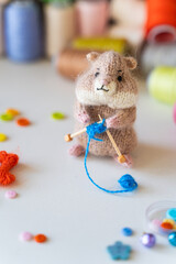 Knitted hamster toy with yarn and knitting accessories