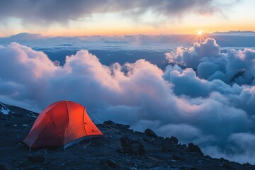 Orange tent on mountain at sunset, above clouds, sun rays peeking, vast sky, lots of copy space