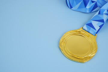Gold medal with number 1 on blue background close up.	 Copy space for text.