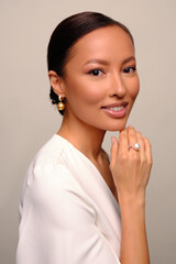 Close up portrait of a beautiful elegant asia woman with stylish jewelry on a white background. Asian cute girl in white dress. Beautiful girl with jewelry.