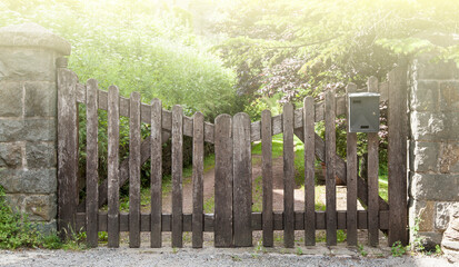 Wooden gate in a stone wall on a farm on sunlight