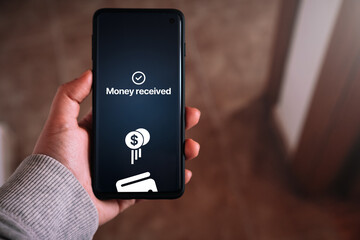 Smartphone screen displaying money transfer confirmation. Woman transfering money online using app...