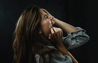 Profile, stress and horror with woman shouting in studio on black background for reaction to fear. Phobia, anxiety and mental health with scared young person screaming in dark for nightmare or terror