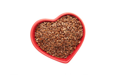 Healthy food. Flax seeds in red heart shaped bowl isolated on white background.