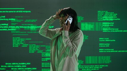 IT specialist against big digital screen. Woman engineer arguing talking on smartphone in front of the screen with digital code error process