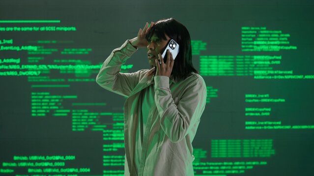 IT specialist against big digital screen. Woman engineer arguing talking on smartphone in front of the screen with digital code error process