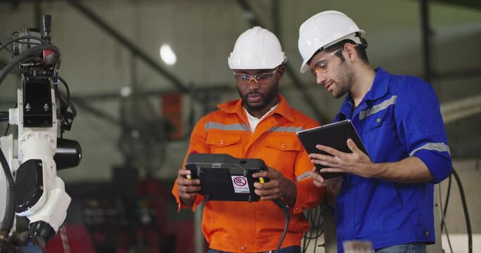 Professional industrial engineer African american man holding automation robot arms machine controller talking to his Chief in smart manufacturing industry. Technology and Innovation concept.