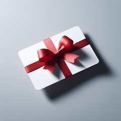 Blank white gift card with red ribbon bow isolated on grey background with shadow minimal conceptual