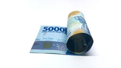 a roll of Indonesian banknotes worth IDR 50,000. Indonesian currency rupiah isolated on white background